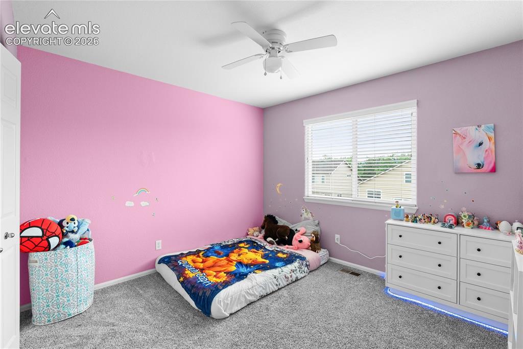 Image 26 of 41: Bedroom featuring a ceiling fan with light fixture, window with blinds, and