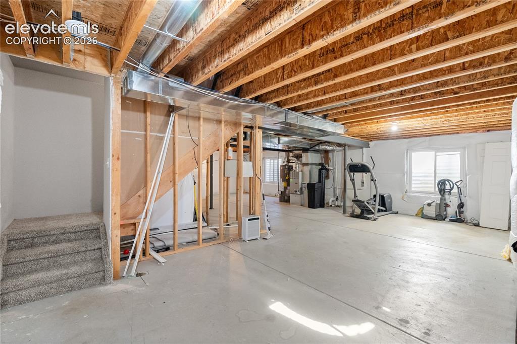 Image 29 of 41: Spacious unfinished basement with exposed wood joists and concrete flooring