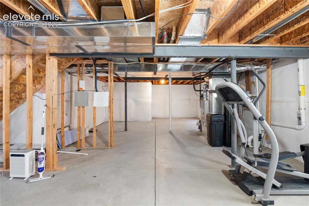 Image 30 of 41: Unfinished basement featuring exposed wood joists and concrete flooring