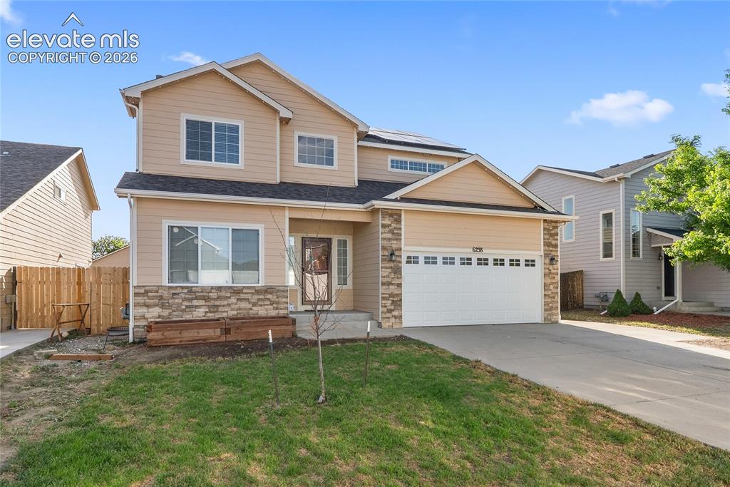 Image 41 of 41: Two-story residence featuring light-toned siding and stone veneer accents