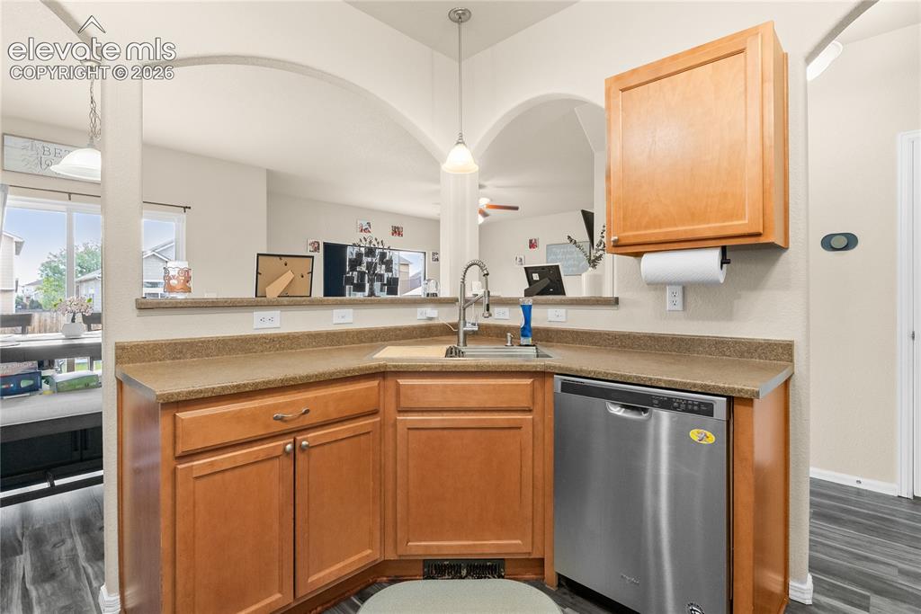 Image 7 of 41: Kitchen featuring wood-finish cabinetry, a stainless steel dishwasher, and 