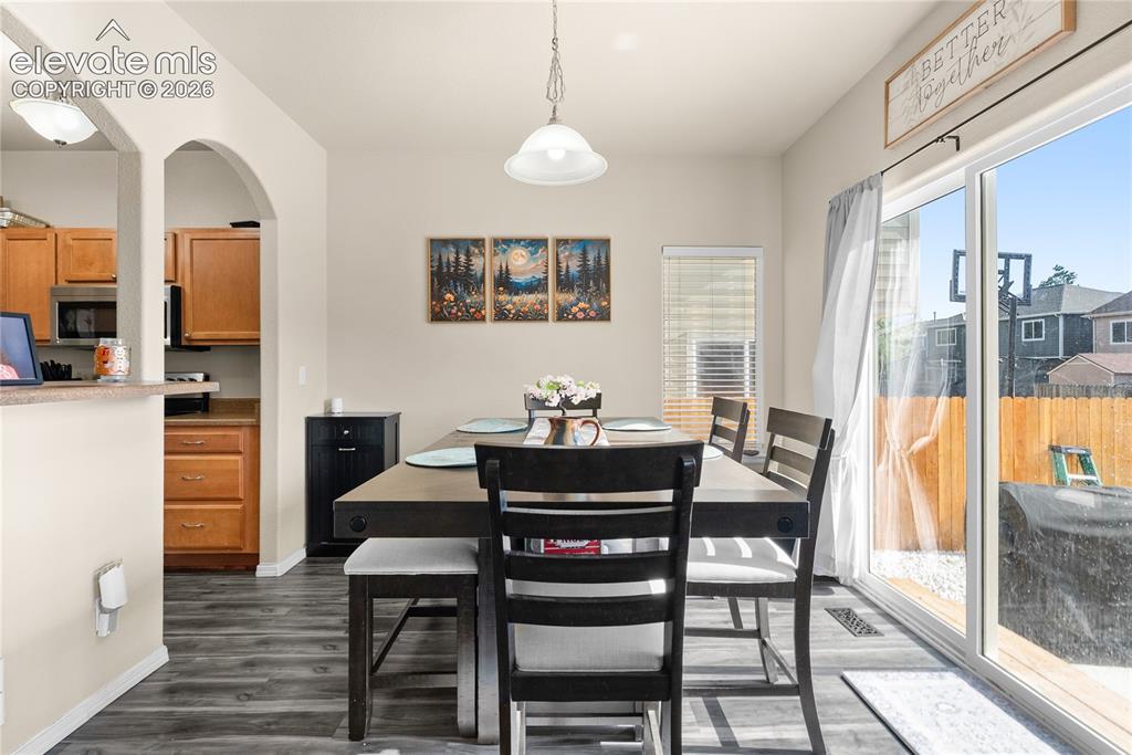 Image 9 of 41: Dining area featuring wood-finish flooring, a contemporary pendant light fi