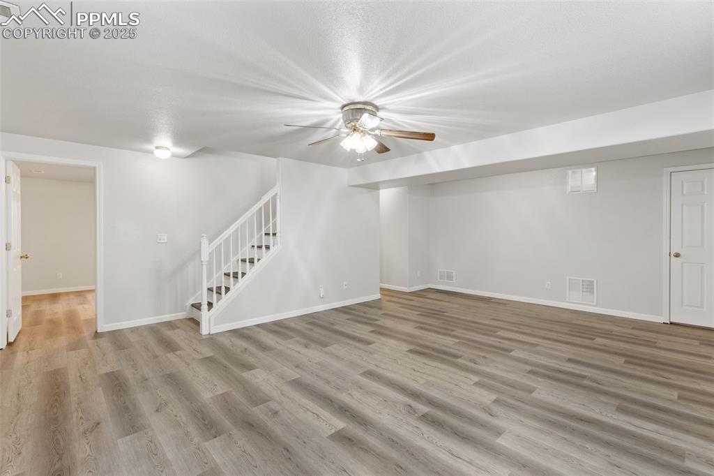 Image 22 of 34: Large rec room with newer laminate flooring
