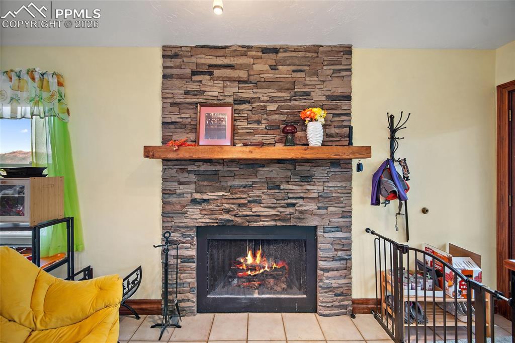 Image 10 of 32: Fireplace in family room open to kitchen.