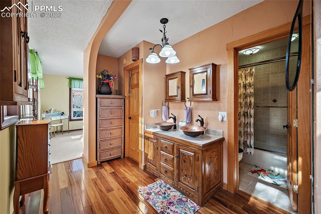 Image 16 of 32: Master Bathroom leading to master bedroom in backrground.