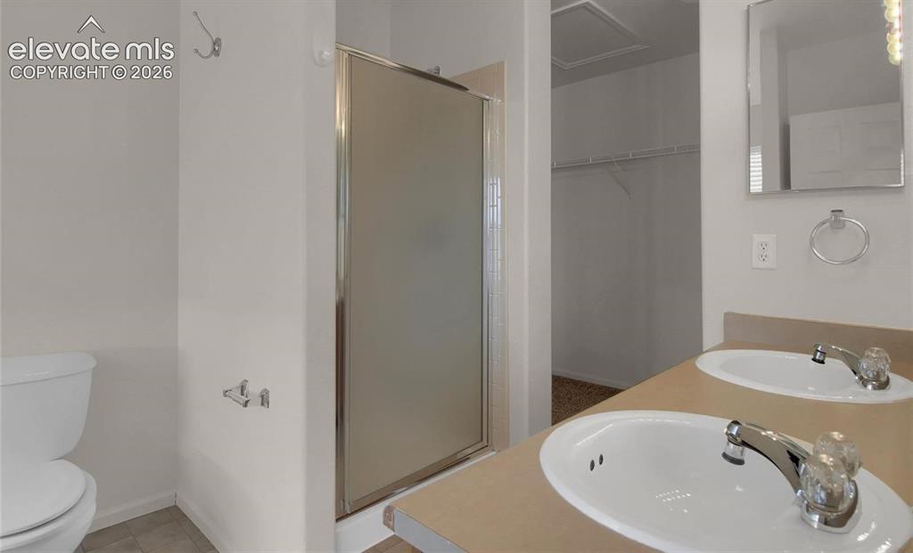 Image 18 of 24: When vacant primary bath facing shower and walk in closet