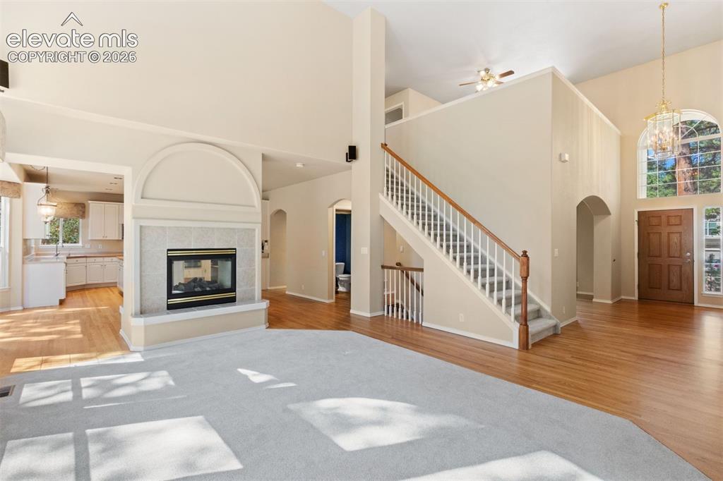 Image 16 of 50: Family room with dual sided fireplace and wall of windows