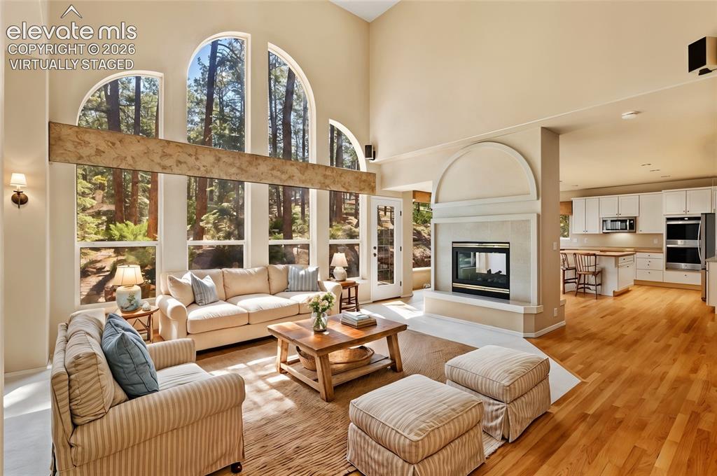 Image 2 of 50: *virtually staged* Family room with dual sided fireplace and wall of window