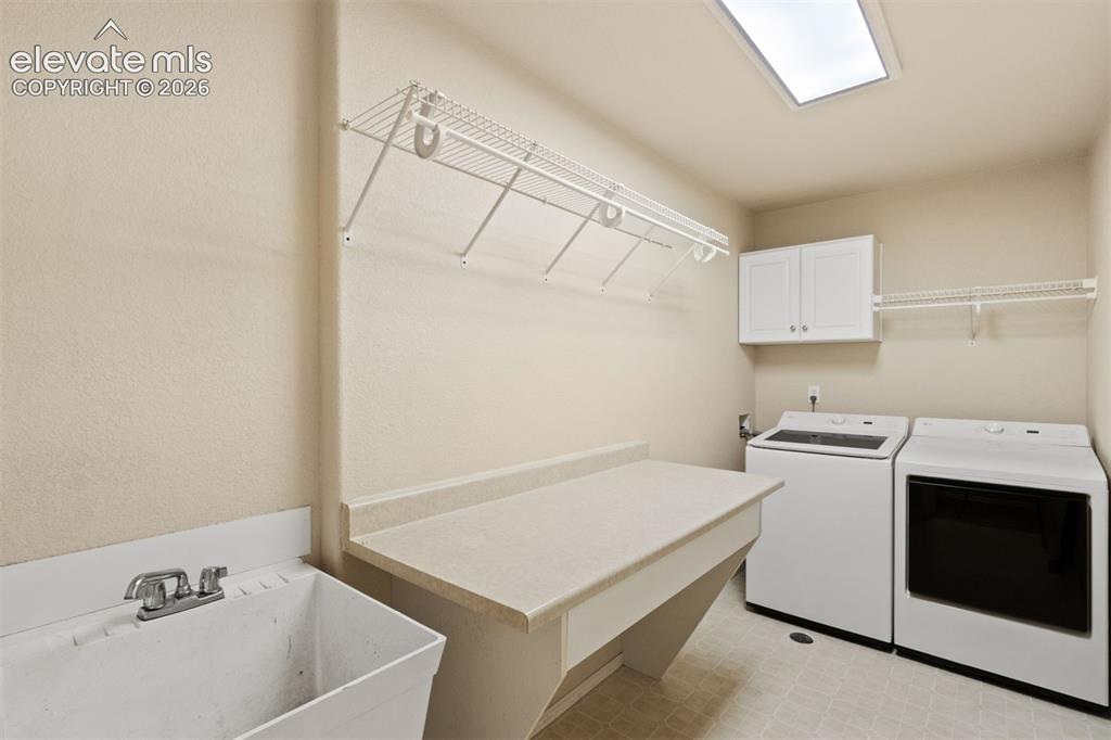 Image 22 of 50: Main level laundry room with storage and sink
