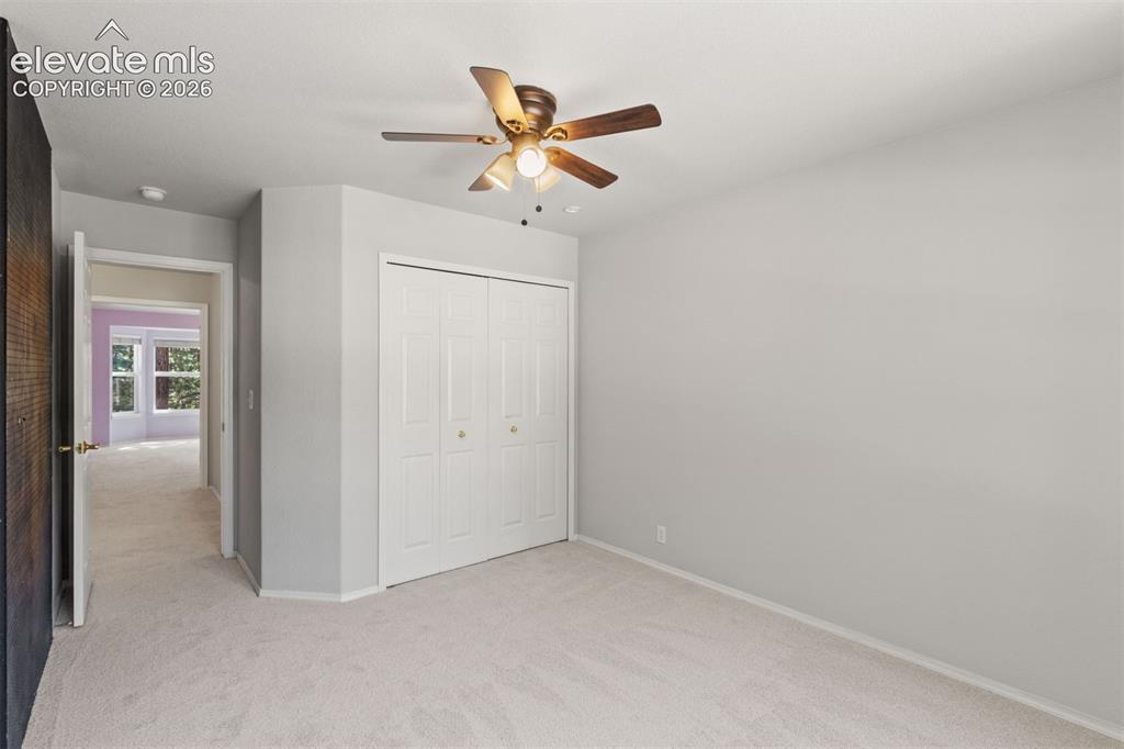 Image 29 of 50: Upstairs bedroom with ceiling fan