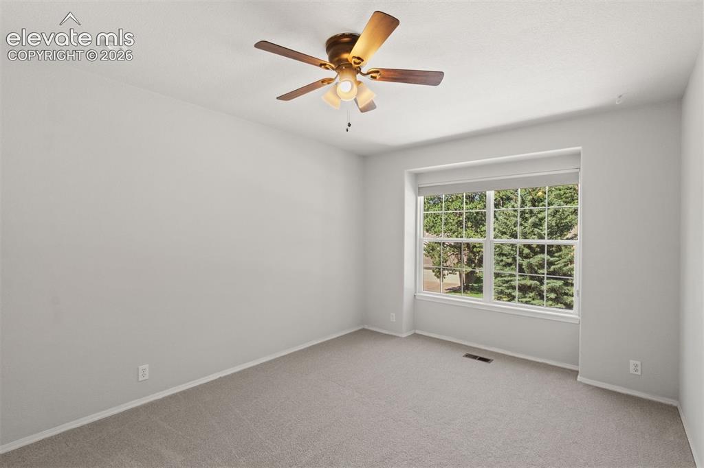 Image 30 of 50: Upstairs bedroom with ceiling fan