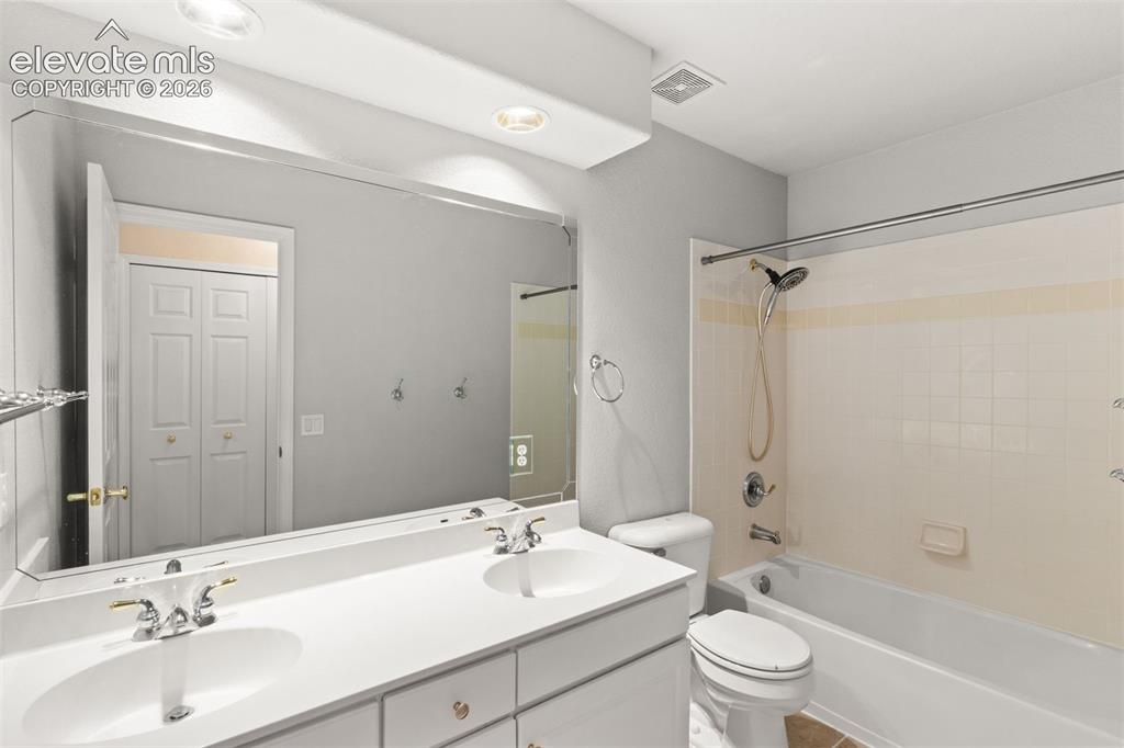 Image 33 of 50: Upstairs full bathroom with dual sink vanities