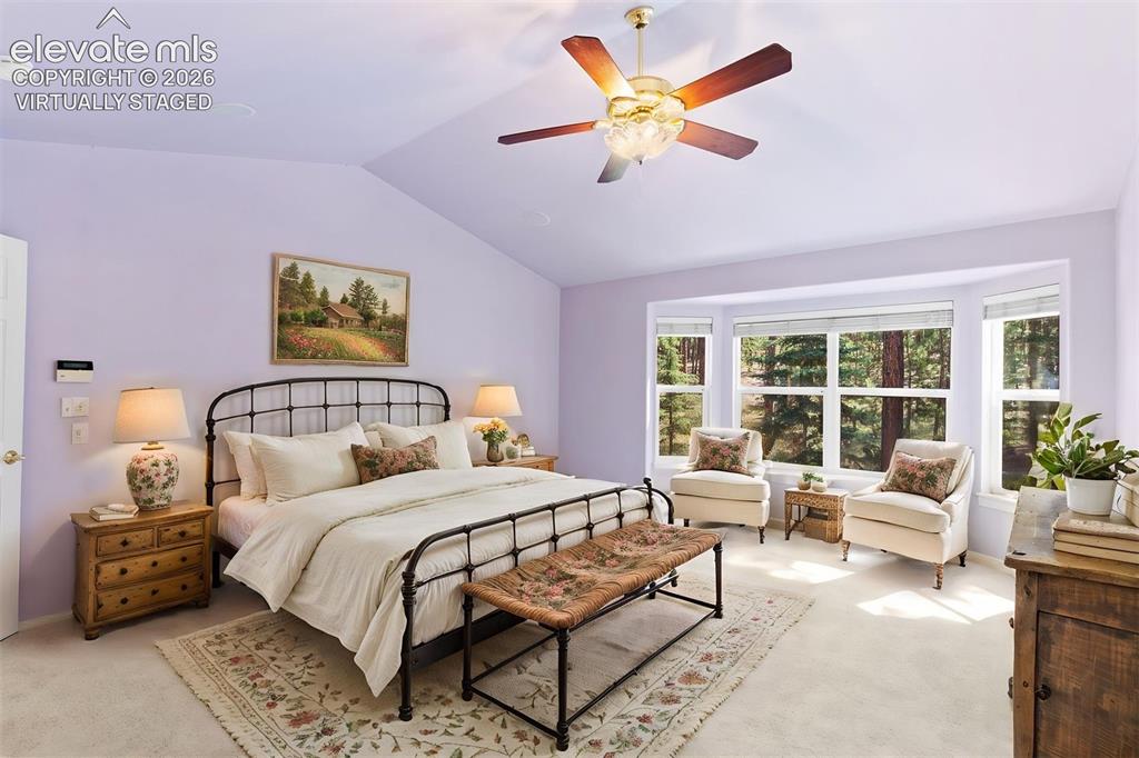 Image 9 of 50: *virtually staged* Primary bedroom with vaulted ceiling, ceiling fan, ensui