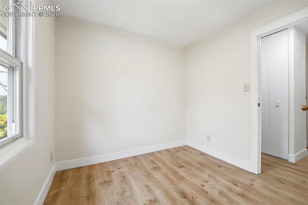 Image 11 of 38: Bedroom featuring light wood-finish flooring, white baseboards, a white win