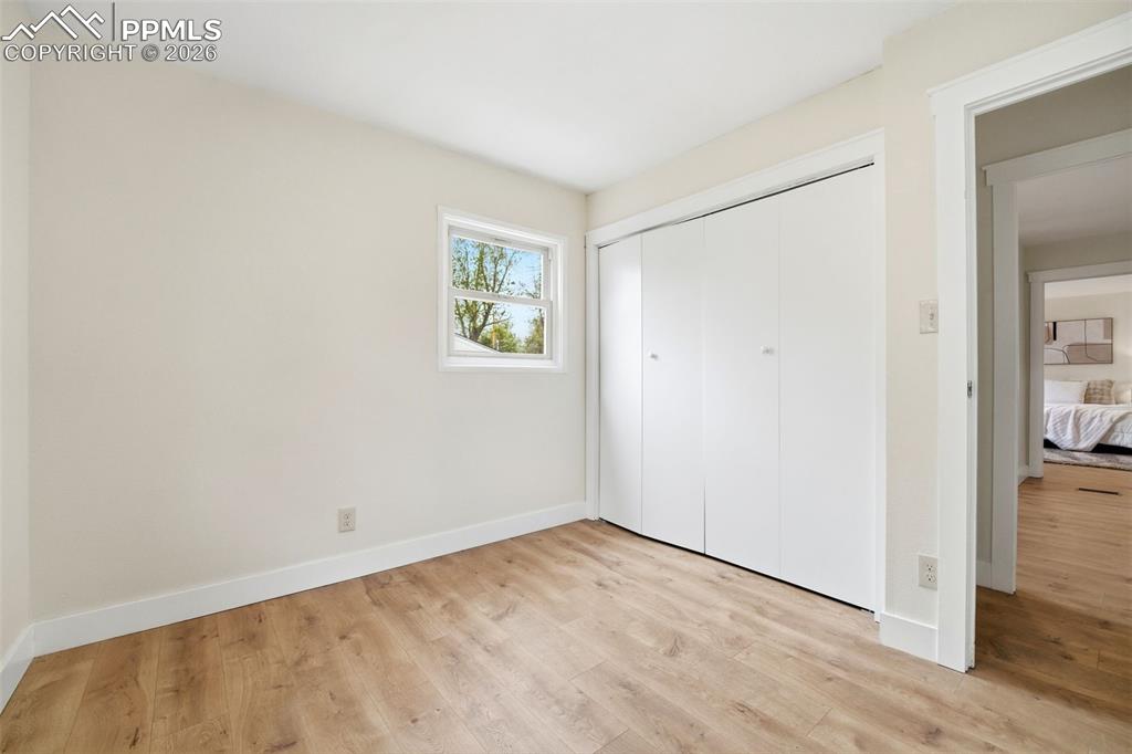Image 14 of 38: Versatile room featuring light wood-finish flooring, white baseboards, and 