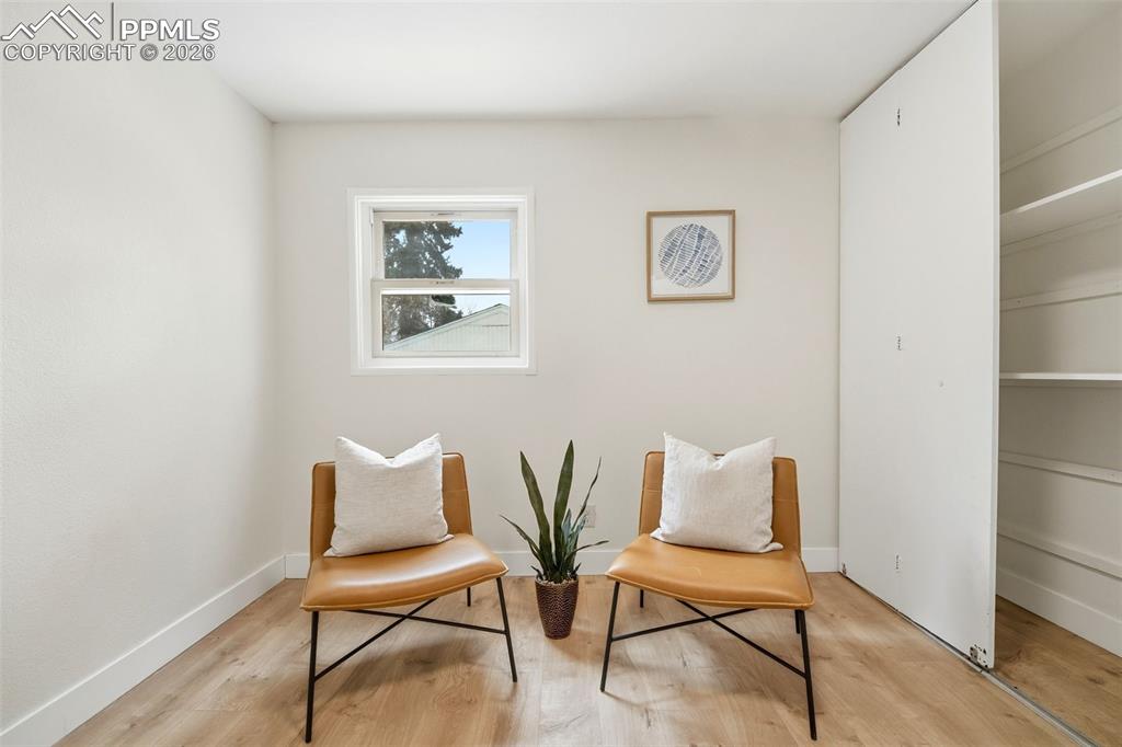 Image 16 of 38: Light wood-finish flooring with white baseboards