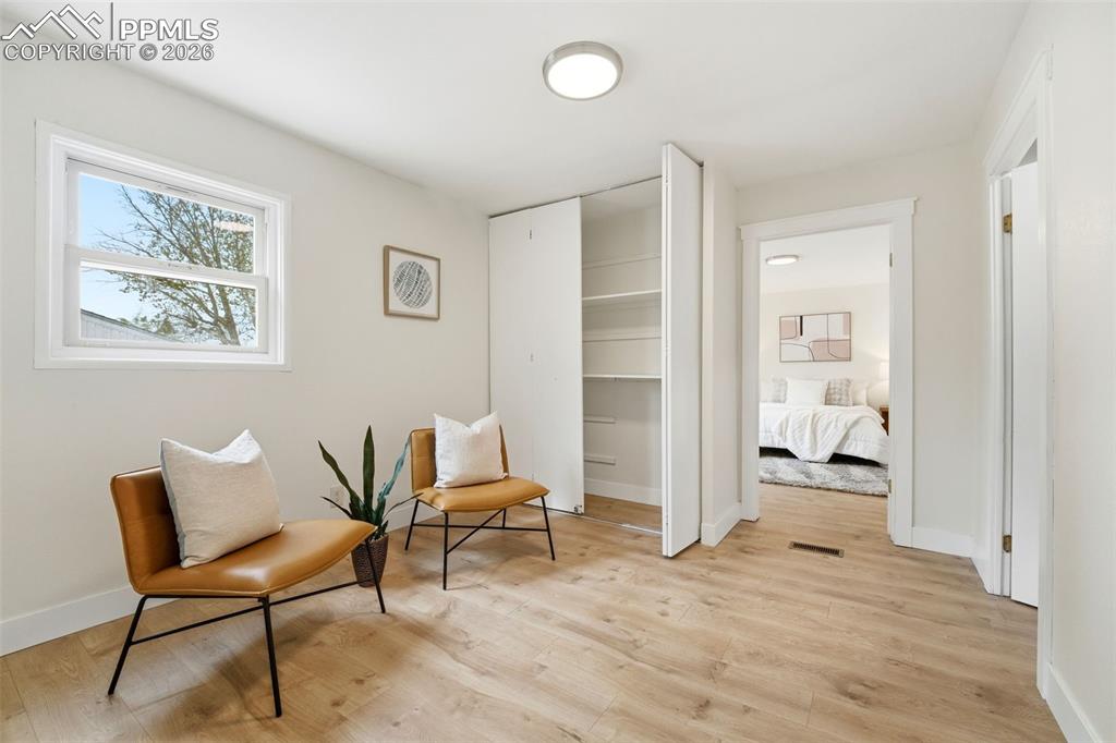 Image 17 of 38: Light-filled room featuring wood-finish flooring, a white window frame, and