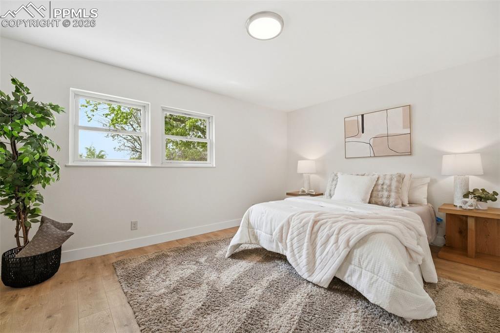 Image 18 of 38: Bright room featuring two windows, wood-finish flooring, a flush-mount ceil