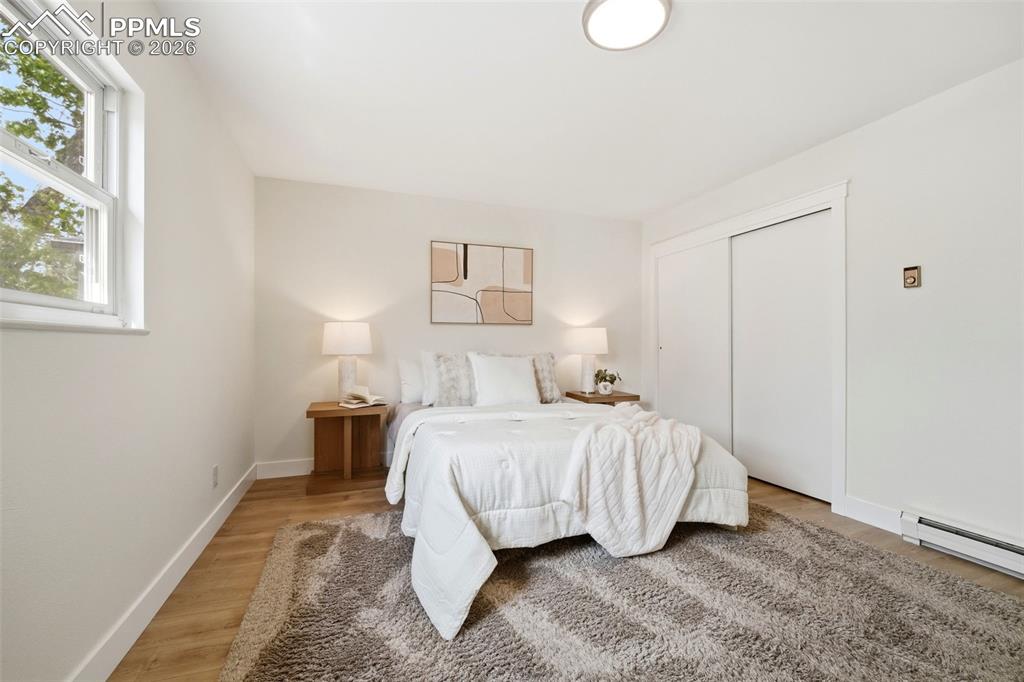 Image 21 of 38: Bright room featuring white walls, wood-finish flooring, a double window, a