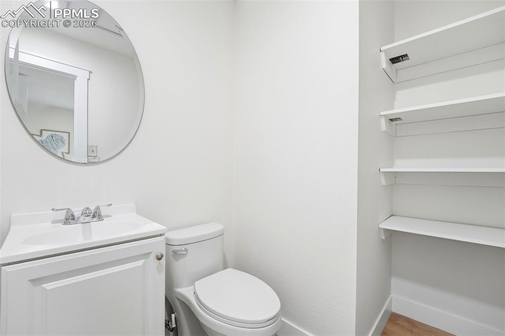Image 22 of 38: White vanity with a rectangular sink and chrome faucet, oval mirror, and op