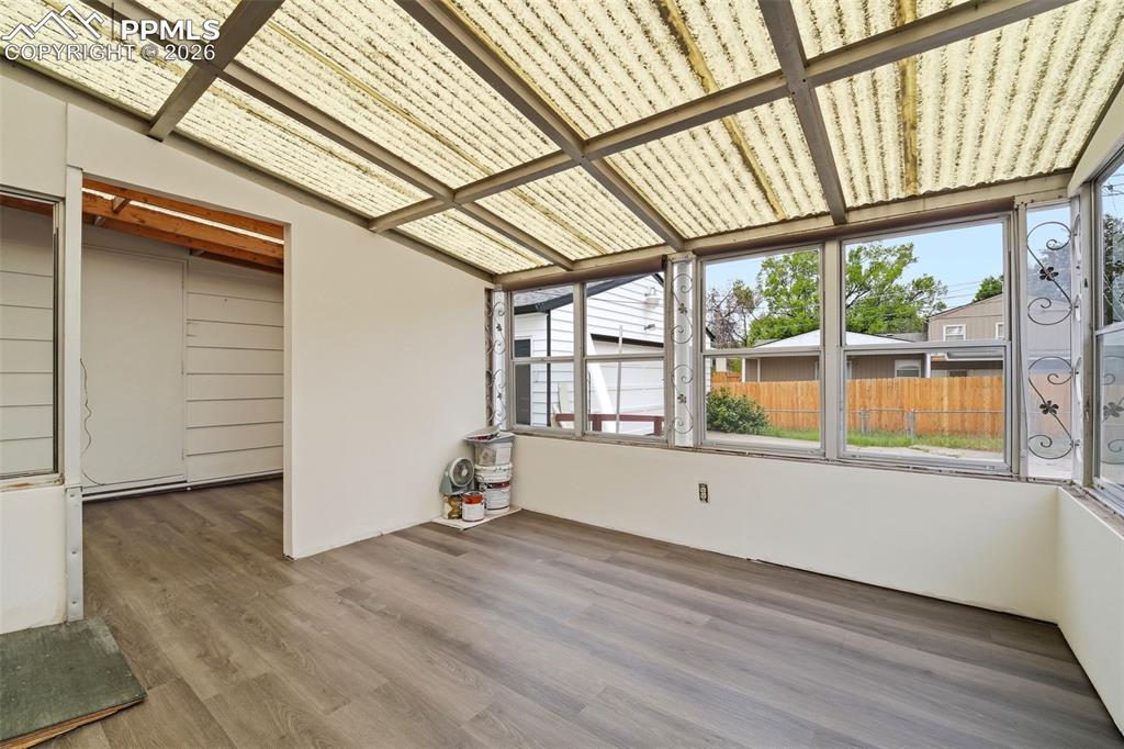 Image 23 of 38: Sunroom featuring a translucent corrugated ceiling, multiple large windows,