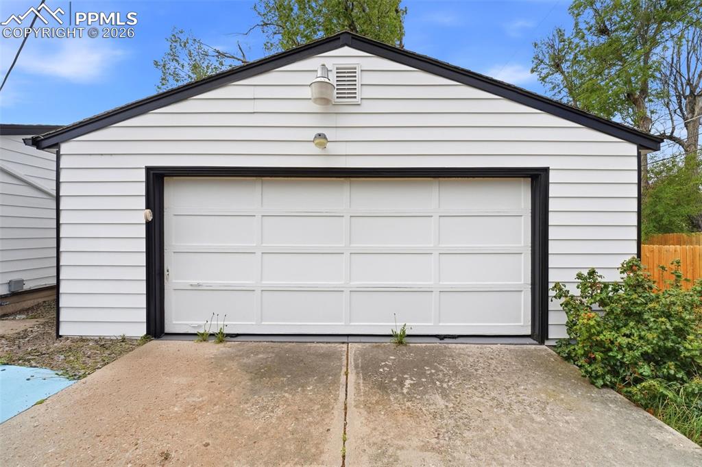 Image 29 of 38: Detached garage featuring white horizontal siding and black trim