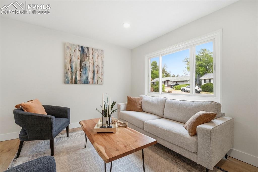 Image 3 of 38: Bright living space featuring a large window, recessed lighting, white trim
