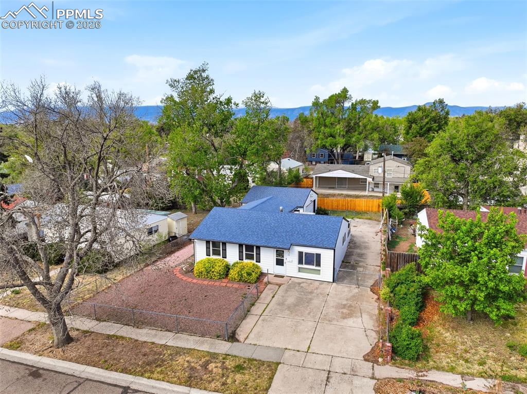 Image 33 of 38: Single-story residence featuring a blue shingle roof, white exterior siding
