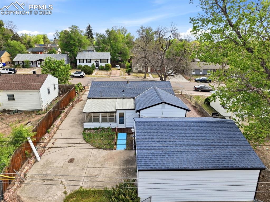 Image 34 of 38: Property featuring a detached garage with a dark shingle roof, a concrete d