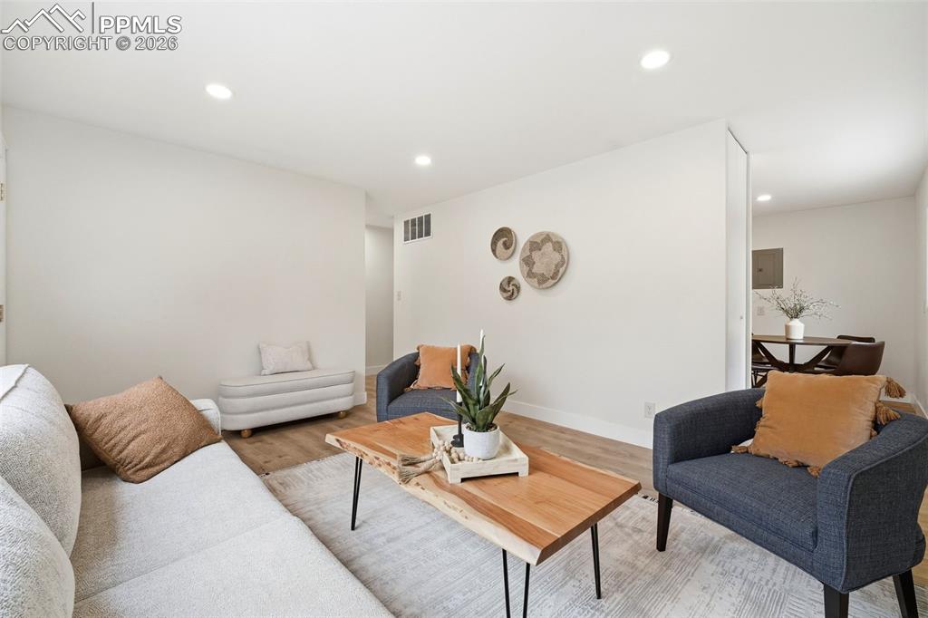 Image 4 of 38: Bright living space featuring recessed lighting, wood-finish flooring, and 