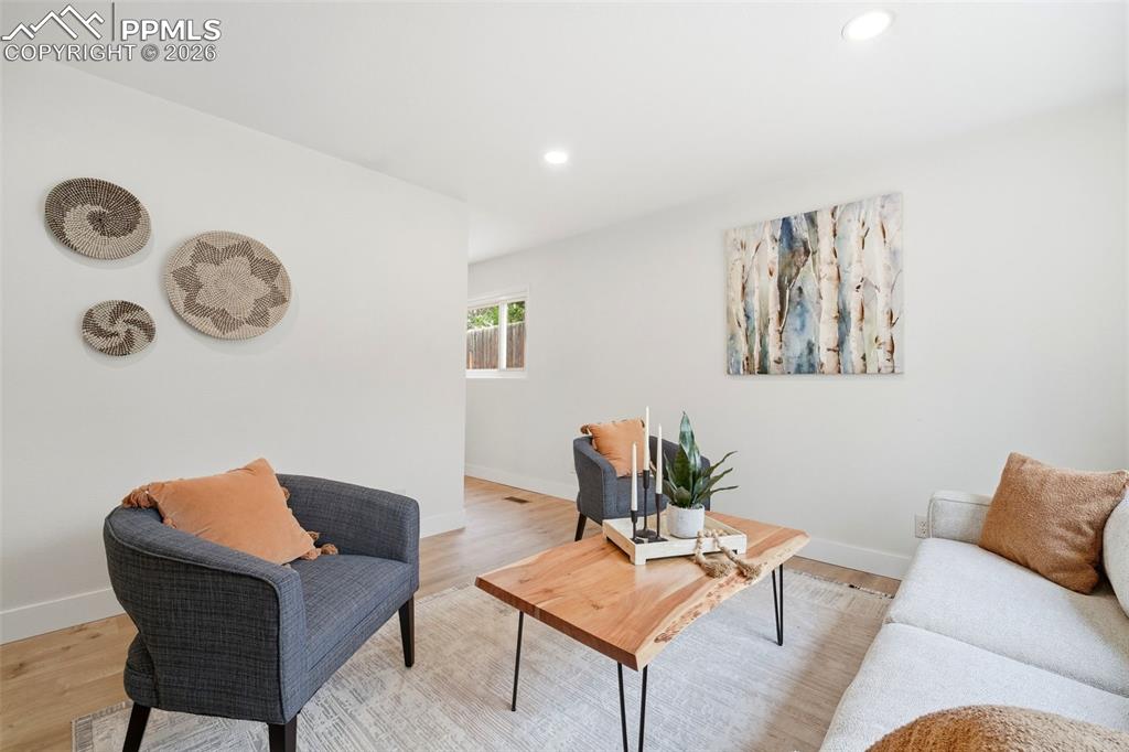Image 5 of 38: Bright living area featuring wood-finish flooring, recessed lighting, and a