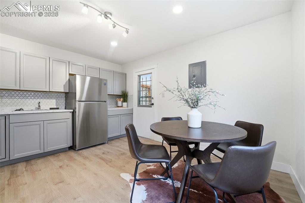 Image 6 of 38: Kitchen area with light wood-finish flooring, light grey cabinetry, and a g