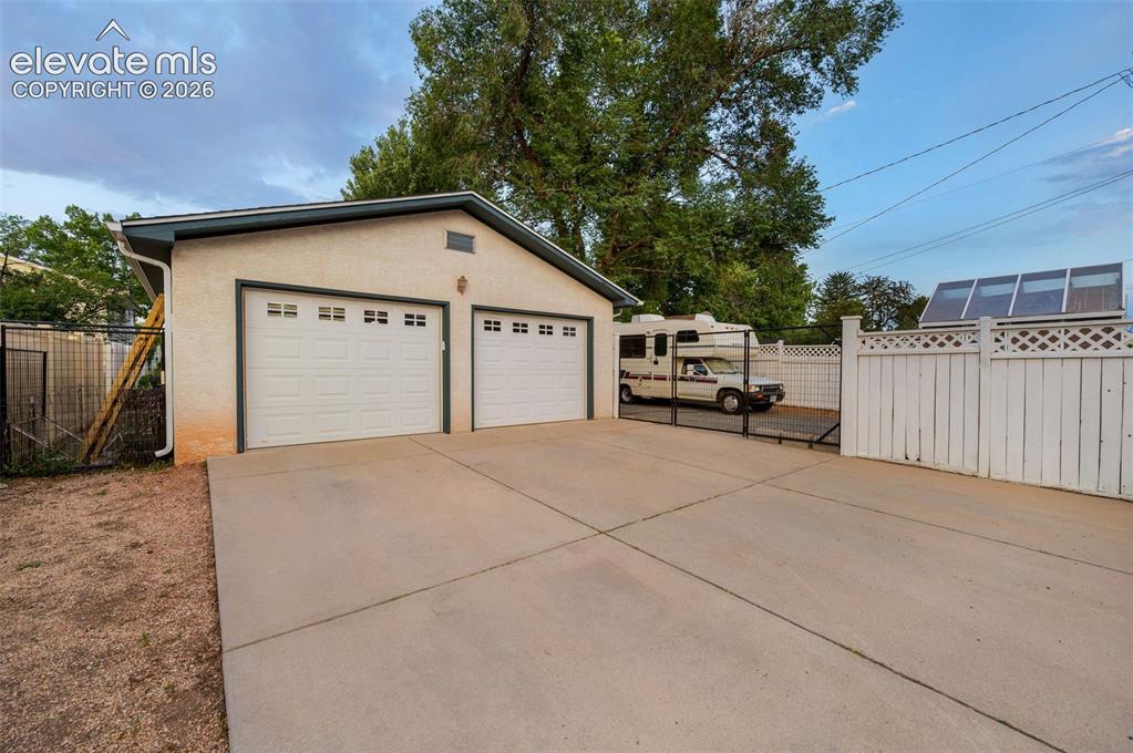 Image 40 of 50: Huge 2 car garage with storage, workbench, and skylight