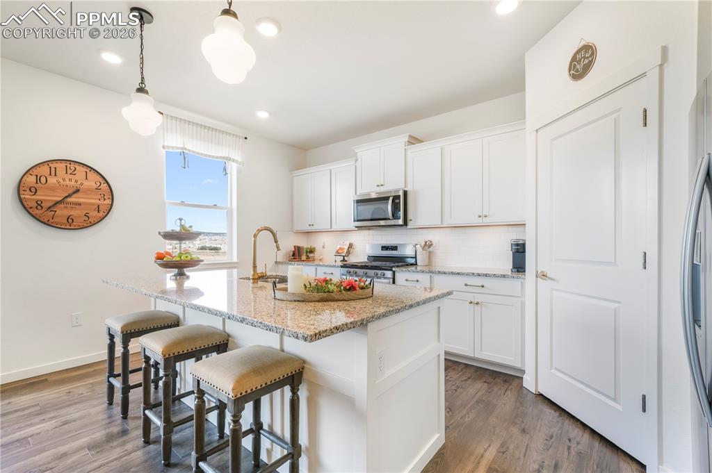 Image 10 of 50: Kitchen with gas range, stainless appliances, walk in pantry, granite count