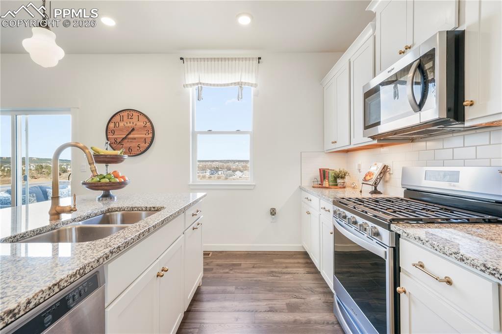 Image 12 of 50: Kitchen with gas range, stainless appliances, walk in pantry, granite count