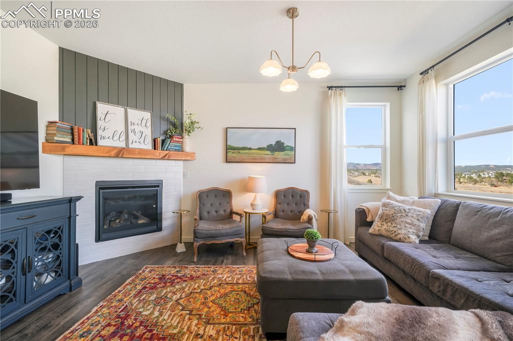 Image 18 of 50: Main level living room with abundant light, gas fireplace