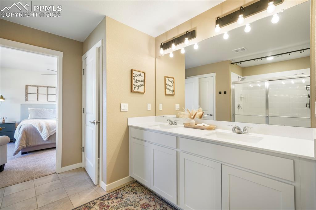Image 26 of 50: Primary bath with dual vanities, quartz counters, large walk in shower, sep