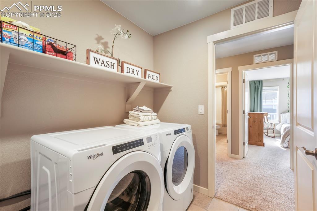 Image 33 of 50: Upstairs laundry area with tile floors