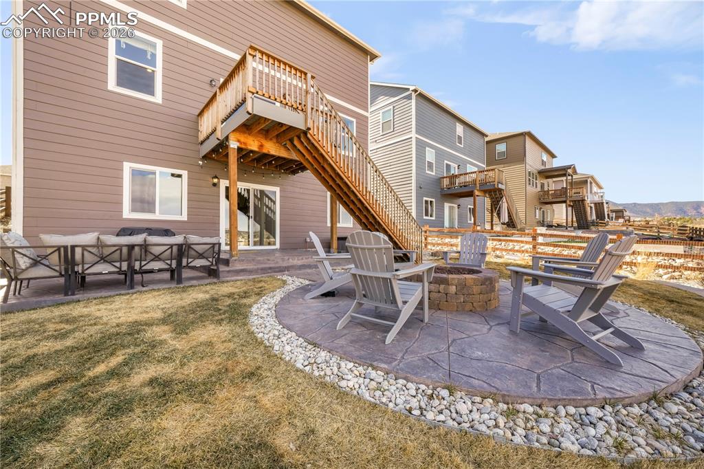 Image 45 of 50: Backyard with gas firepit, fenced yard, tiered stamp concrete patio areas a