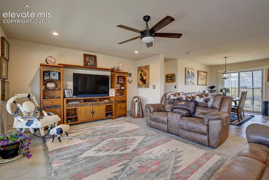 Image 10 of 50: Open-concept living area featuring a ceiling fan with integrated lighting, 