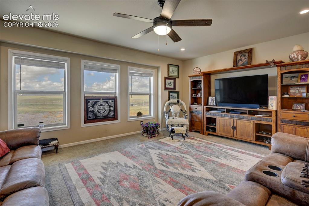 Image 11 of 50: Neutral wall paint, three large windows, recessed lighting, and a ceiling f