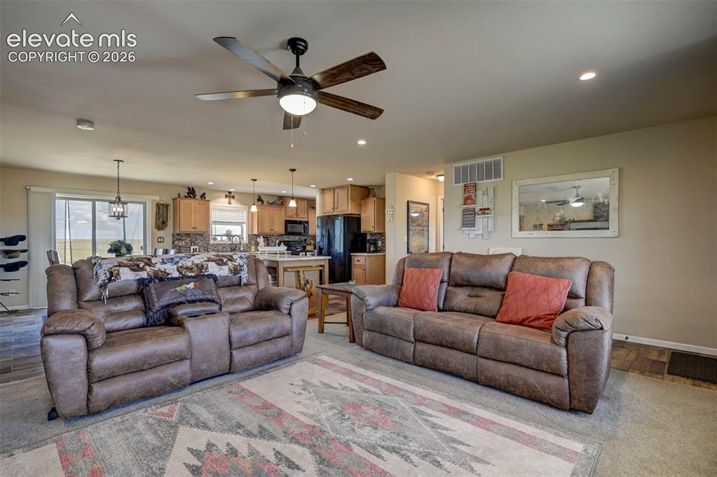 Image 13 of 50: Recessed lighting, ceiling fan, wood-finish flooring, kitchen cabinetry, an