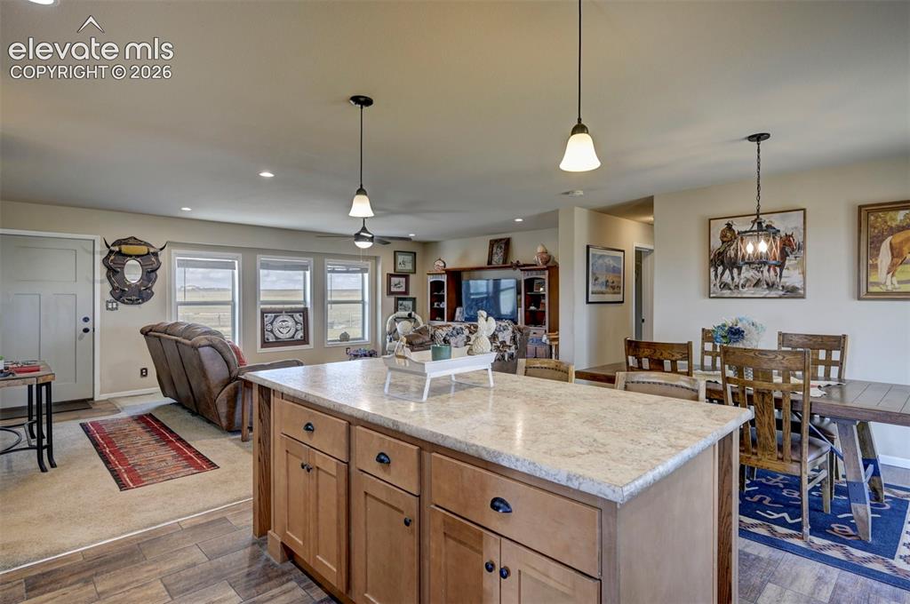 Image 20 of 50: Kitchen island with a light-toned countertop and wood-finish cabinetry