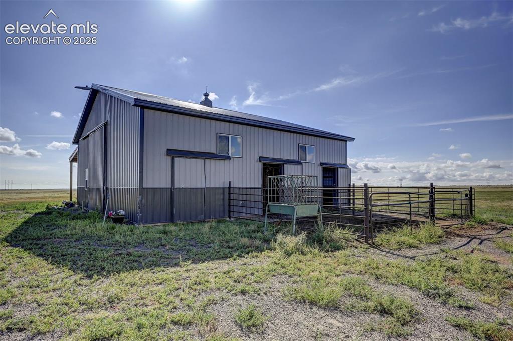 Image 38 of 50: Metal-sided barn featuring a gambrel roof and multiple windows