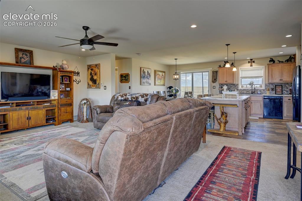 Image 9 of 50: Open-concept living space featuring a ceiling fan, recessed lighting, and w
