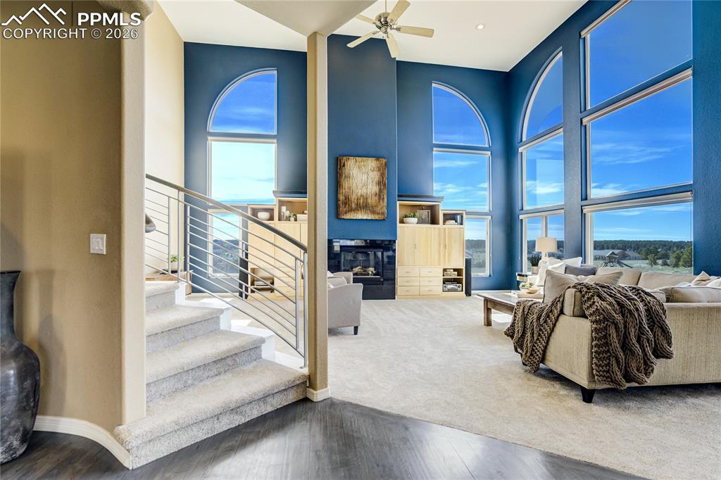 Image 11 of 50: The great room is defined by 18’ ceilings, expansive windows, and a gas fir