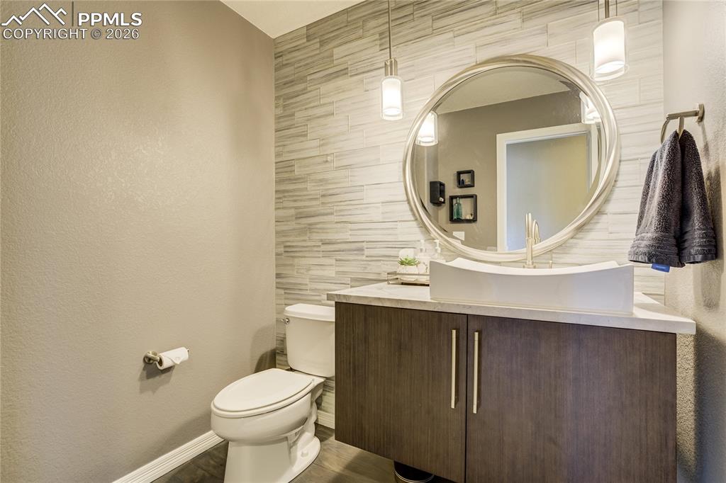 Image 26 of 50: Remodeled powder room featuring a modern vanity with vessel sink, quartz co