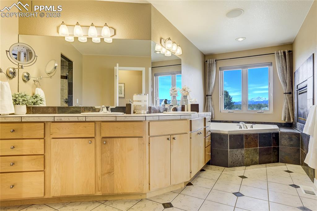 Image 32 of 50:  The five-piece bath includes a jetted tub, walk-in shower with dual heads 