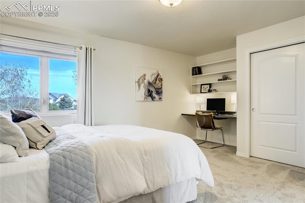 Image 36 of 50: The upper level includes two additional bedrooms with built-in workstations