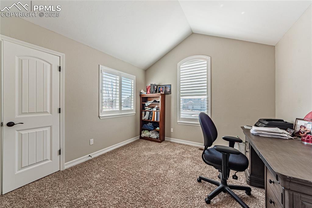 Image 16 of 36: Carpeted office featuring baseboards and lofted ceiling